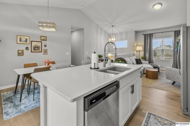 kitchen with sink, hanging light fixtures, an island with sink, stainless steel appliances, and white cabinets