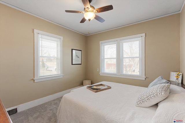 carpeted bedroom with crown molding, ceiling fan, and multiple windows