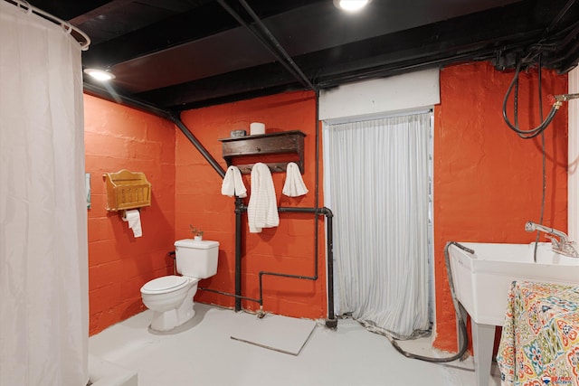 bathroom with concrete floors and toilet