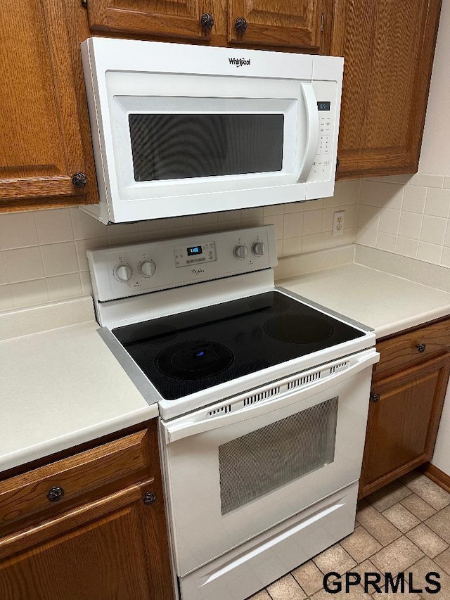 kitchen with white appliances and decorative backsplash