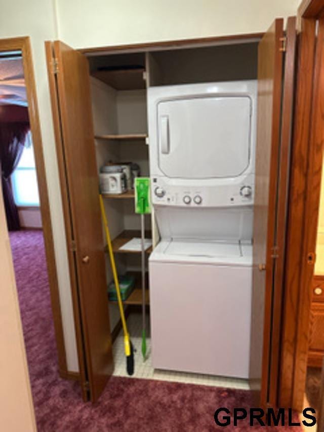 washroom featuring stacked washer and dryer and carpet floors