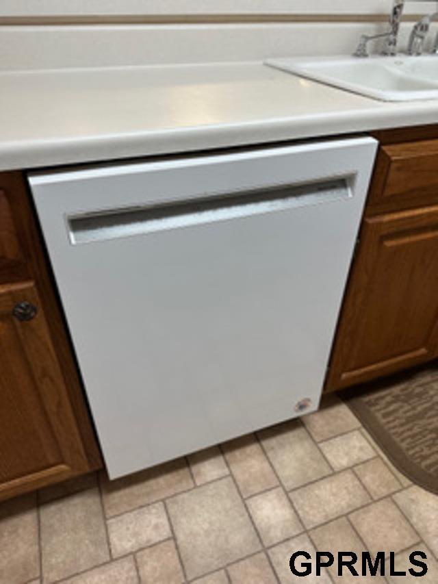 interior space with white dishwasher and sink