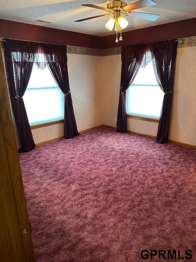 carpeted spare room with ceiling fan and a textured ceiling