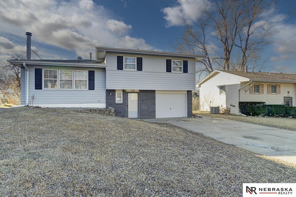 tri-level home with a garage and central air condition unit