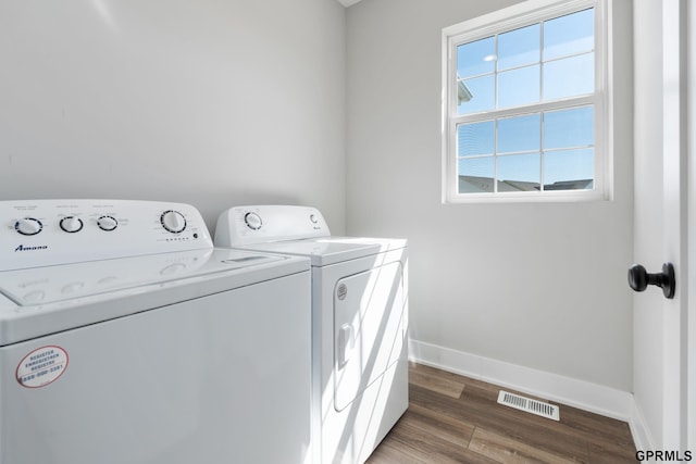 laundry area with dark hardwood / wood-style floors and washer and clothes dryer