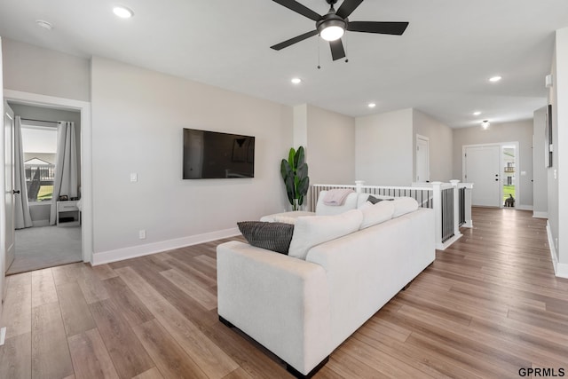 living room with ceiling fan, a healthy amount of sunlight, and light wood-type flooring