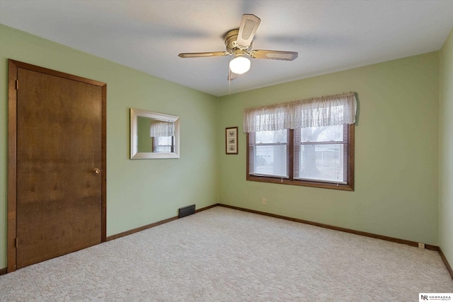 carpeted spare room with ceiling fan