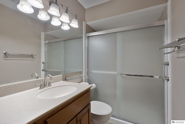 bathroom with a shower with door, vanity, a chandelier, and toilet