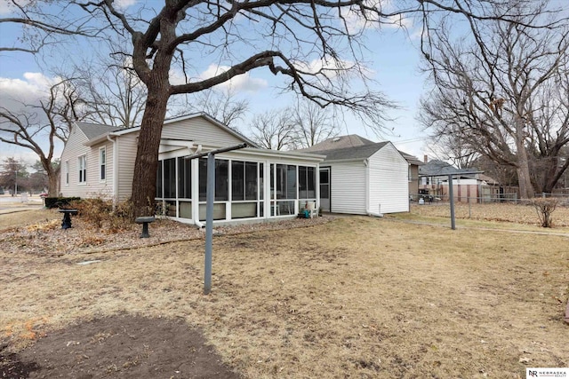 back of house with a yard and a sunroom