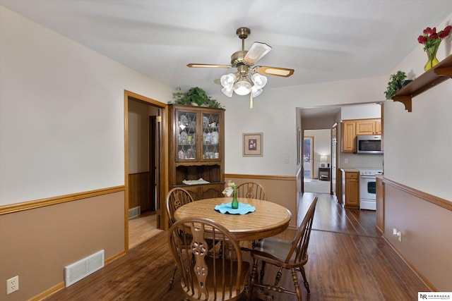 dining space with dark wood-type flooring and ceiling fan