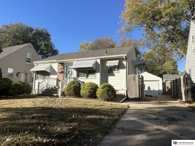 view of front of house featuring an outbuilding, a garage, and a front lawn