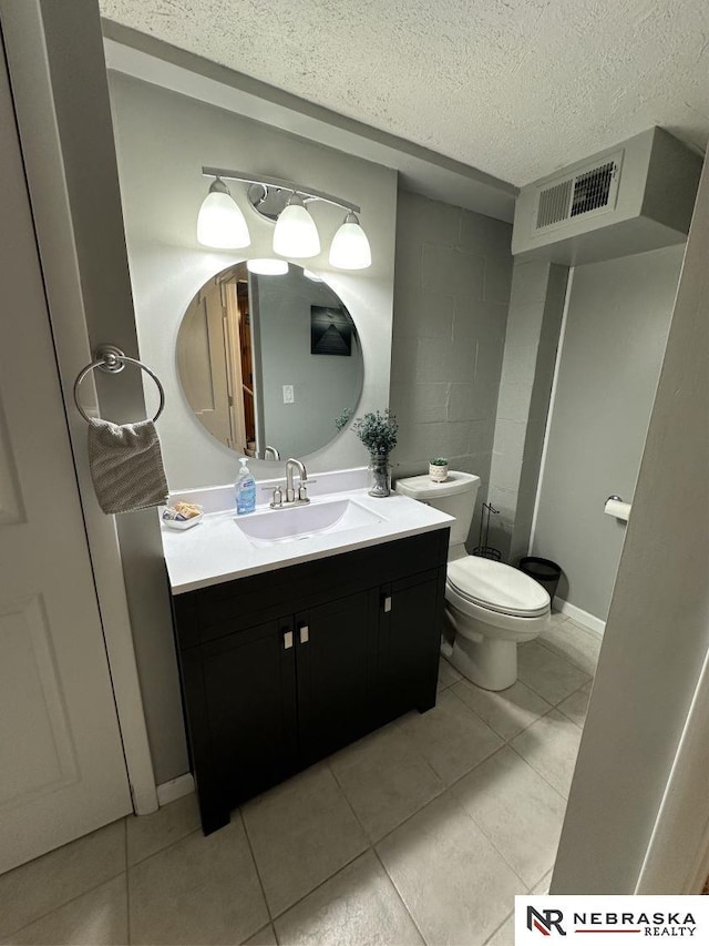 bathroom featuring vanity, tile patterned floors, a textured ceiling, and toilet