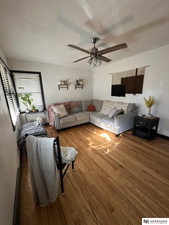 living room with hardwood / wood-style flooring, a textured ceiling, and ceiling fan