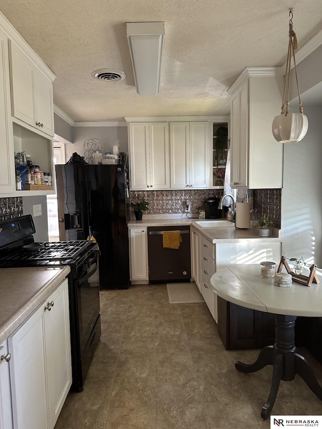 kitchen featuring white cabinetry, sink, hanging light fixtures, and black appliances