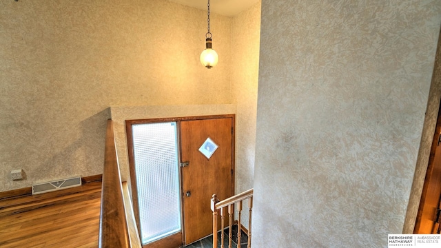 entryway with a towering ceiling and wood-type flooring