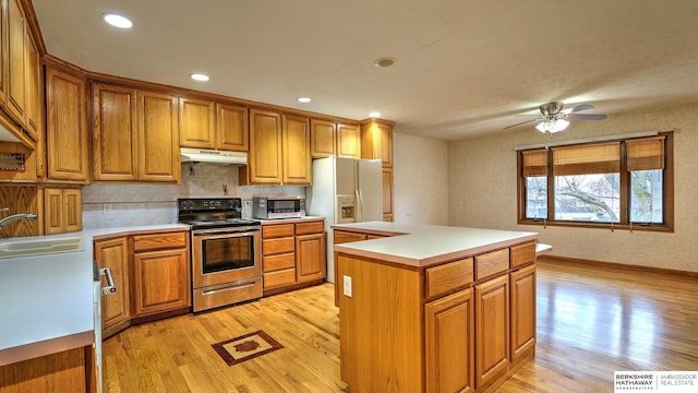 kitchen featuring sink, a kitchen island, light hardwood / wood-style floors, and appliances with stainless steel finishes