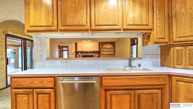 kitchen featuring plenty of natural light, sink, stainless steel dishwasher, and kitchen peninsula