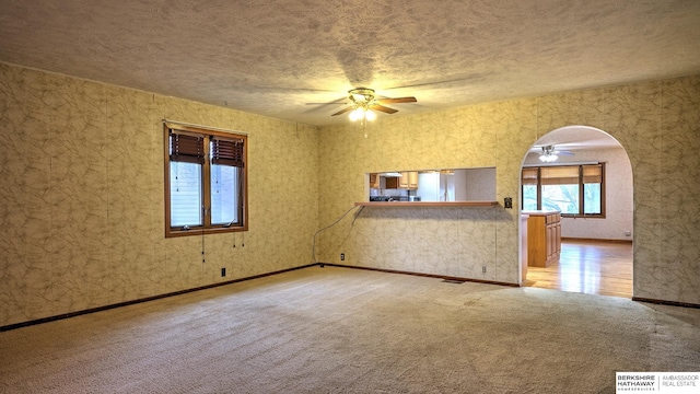 carpeted empty room with a textured ceiling and ceiling fan