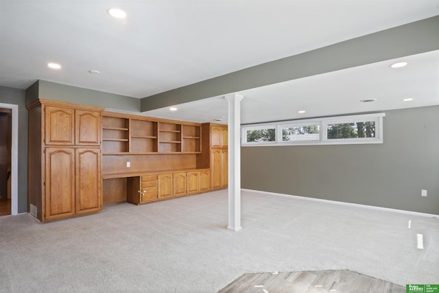 basement with light carpet and built in desk