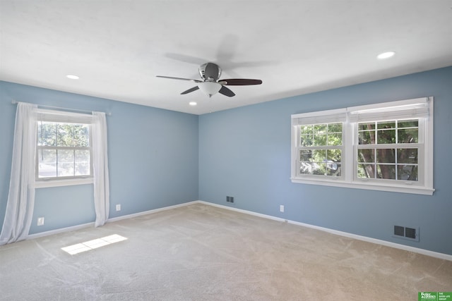 unfurnished room with ceiling fan and light carpet