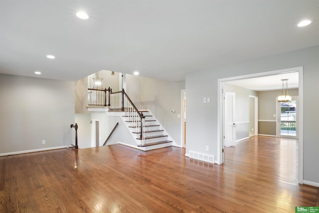 interior space featuring wood-type flooring and an inviting chandelier