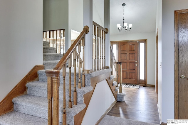 entryway featuring hardwood / wood-style flooring, a chandelier, and high vaulted ceiling