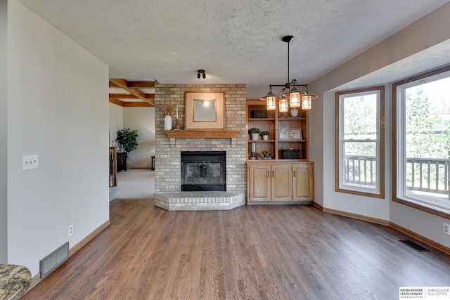 unfurnished living room featuring hardwood / wood-style flooring, a textured ceiling, and a fireplace