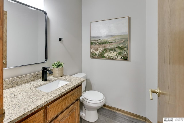 bathroom with vanity, hardwood / wood-style floors, and toilet