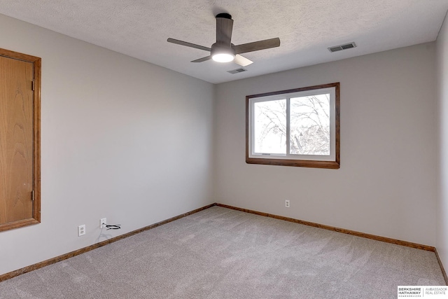 carpeted empty room featuring ceiling fan and a textured ceiling