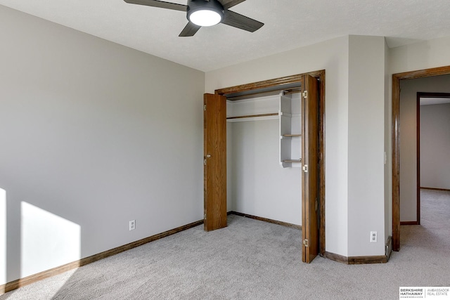 unfurnished bedroom featuring ceiling fan, light colored carpet, and a closet