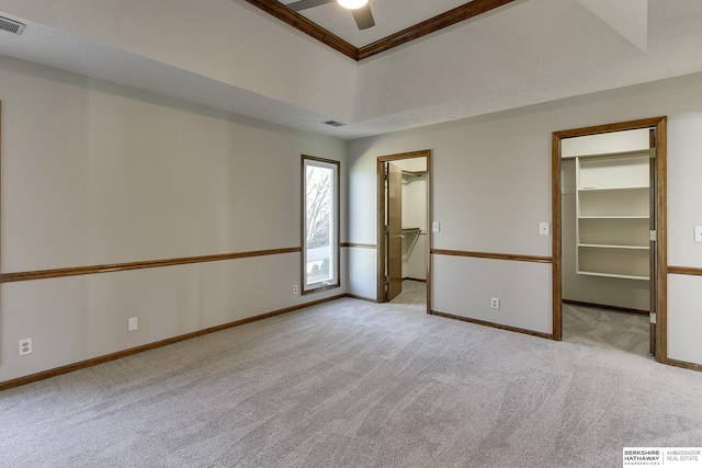 unfurnished bedroom with a spacious closet, light carpet, and a closet