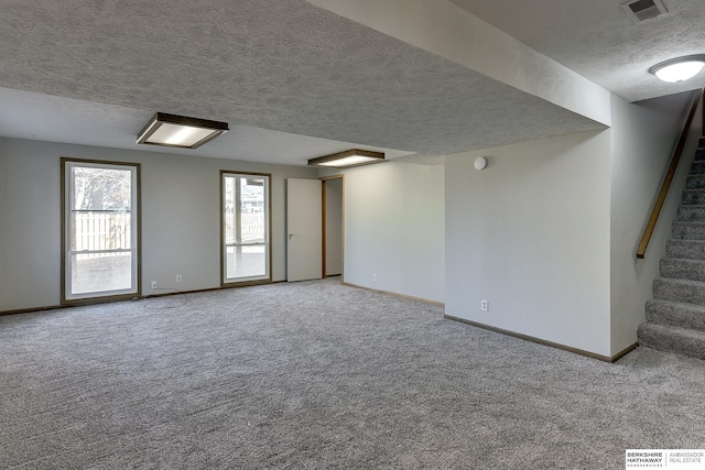 spare room with light colored carpet and a textured ceiling