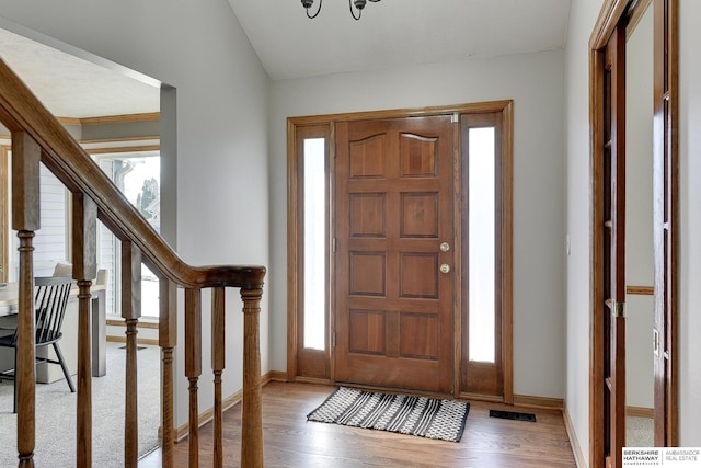 entryway featuring wood-type flooring, lofted ceiling, and a healthy amount of sunlight