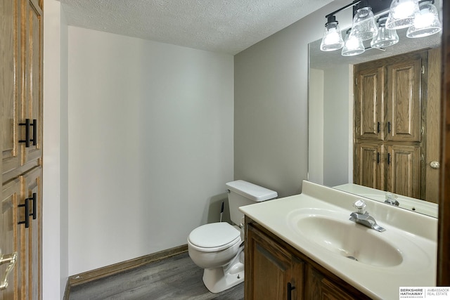 bathroom with vanity, a textured ceiling, toilet, and hardwood / wood-style flooring