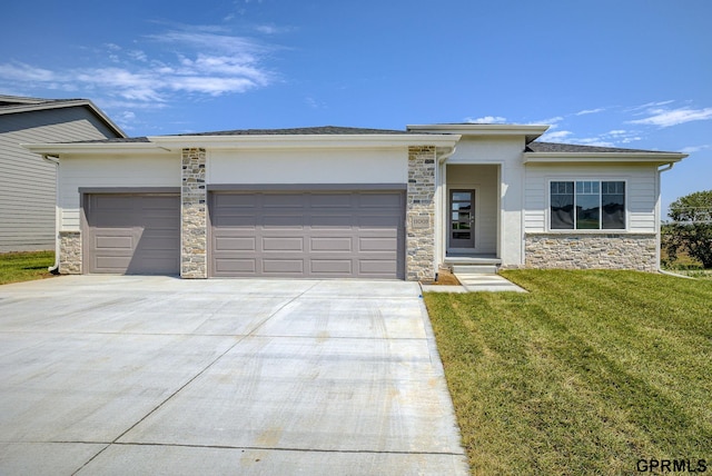 prairie-style house with a garage, stone siding, driveway, and a front yard