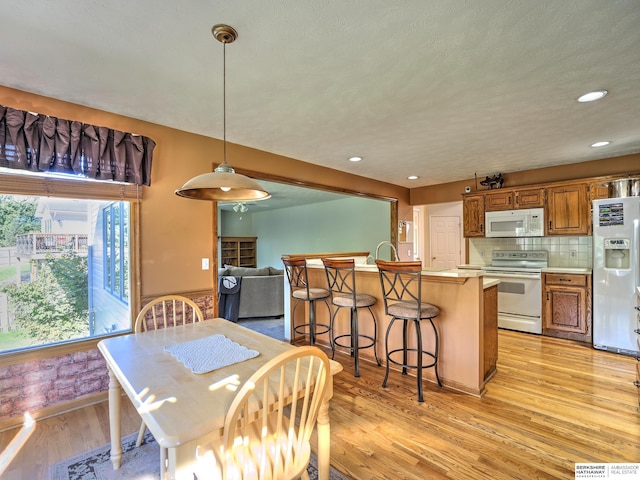 dining area with a healthy amount of sunlight and light hardwood / wood-style floors