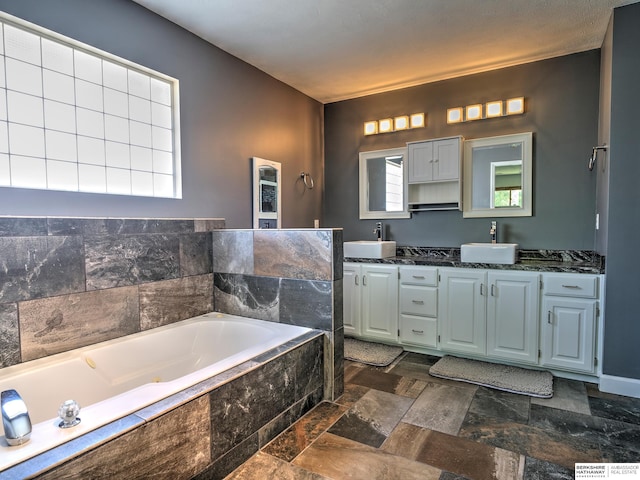 bathroom featuring vanity and tiled tub