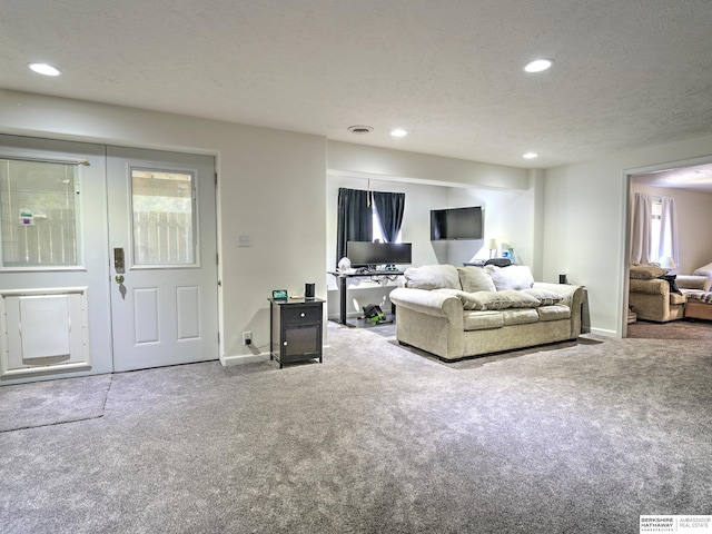 carpeted living room featuring a textured ceiling