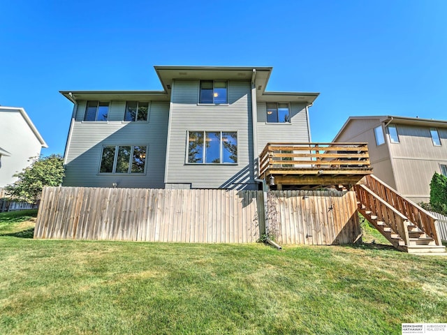 back of property featuring a deck and a lawn