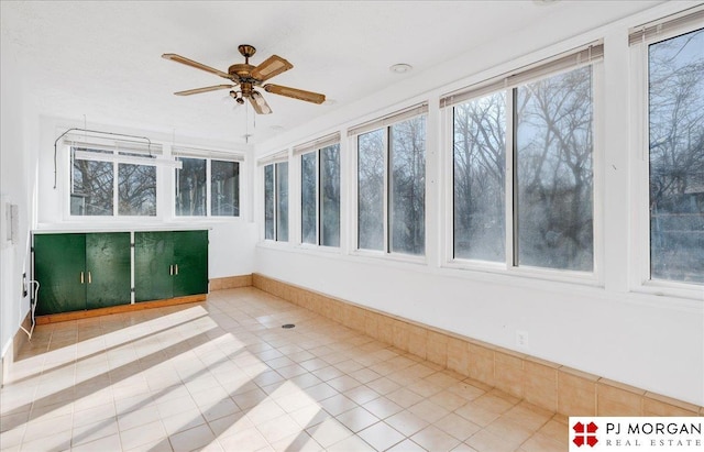 unfurnished sunroom featuring ceiling fan