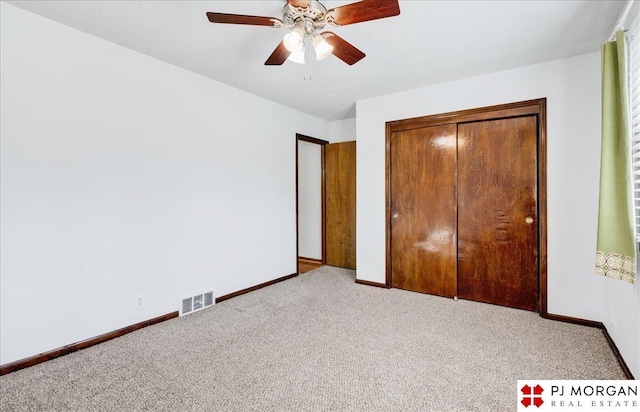 unfurnished bedroom with light carpet, a closet, and ceiling fan