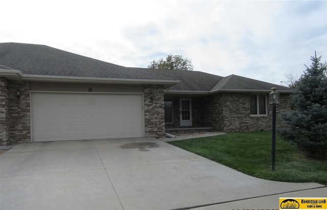 ranch-style house featuring a garage and a front lawn