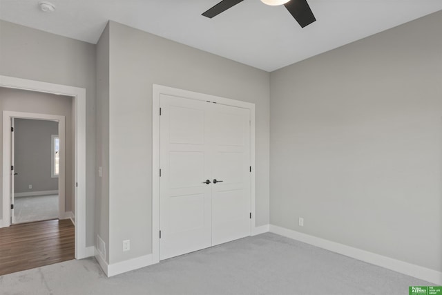 unfurnished bedroom featuring a ceiling fan, carpet, baseboards, and a closet