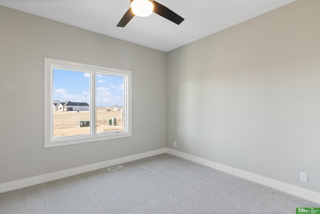 empty room featuring a ceiling fan, carpet, visible vents, and baseboards