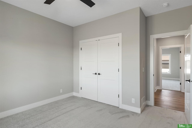 unfurnished bedroom with carpet, a closet, visible vents, ceiling fan, and baseboards