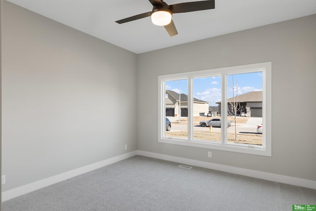 unfurnished room with a ceiling fan, carpet, visible vents, and baseboards