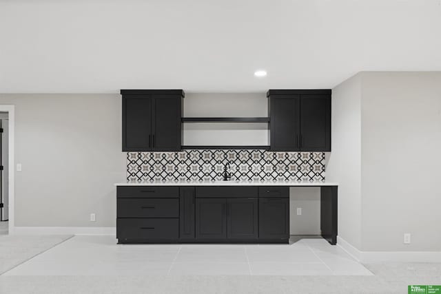 kitchen featuring light countertops, a sink, and backsplash