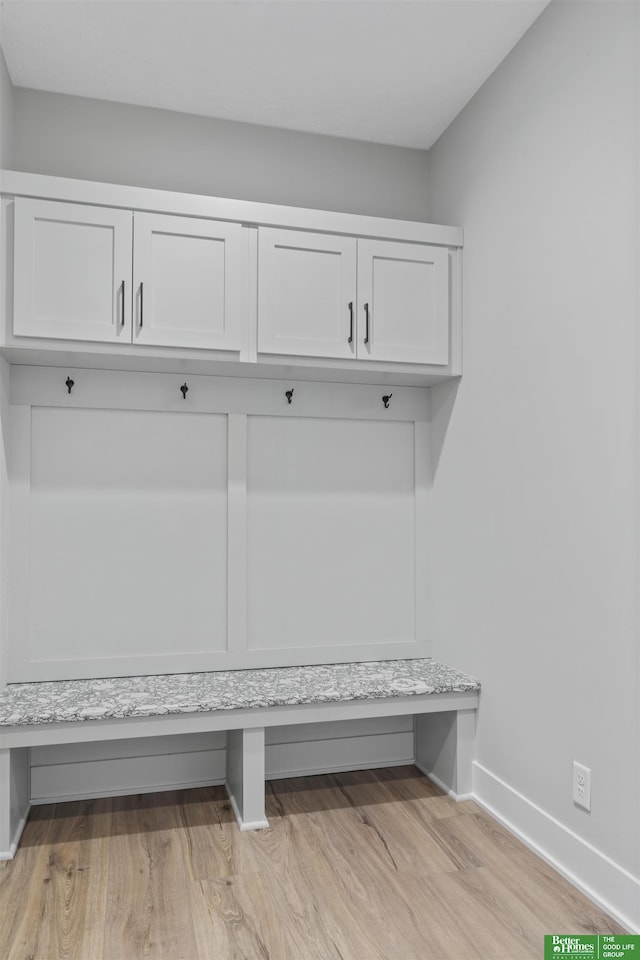 mudroom featuring light wood finished floors and baseboards