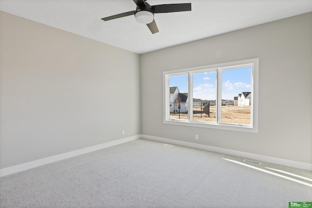 empty room featuring baseboards, a ceiling fan, visible vents, and light colored carpet