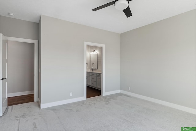 unfurnished bedroom featuring carpet floors, connected bathroom, baseboards, and a ceiling fan